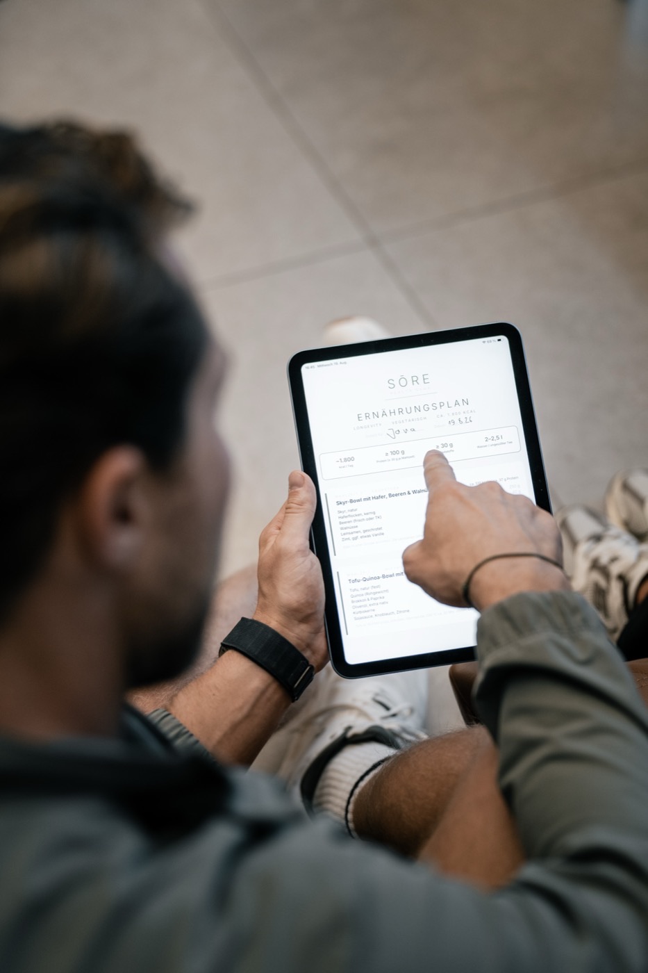 Mitglied liest den SŌRE Ern&auml;hrungsplan auf dem Tablet