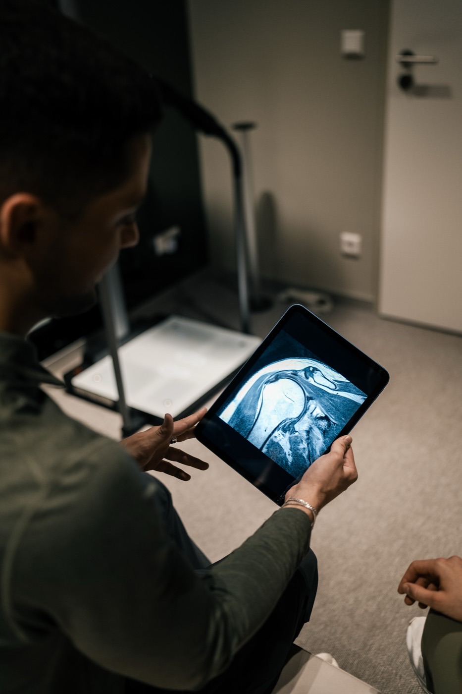 Trainer bespricht eine MRT-Aufnahme auf dem Tablet im SŌRE Health Club
