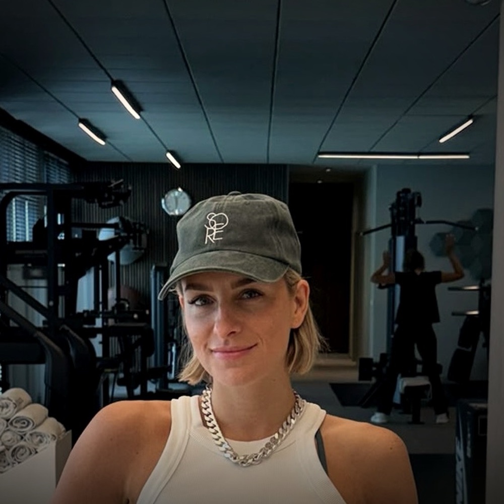 Mitglied mit olivfarbener SŌRE-Cap auf der Trainingsfl&auml;che