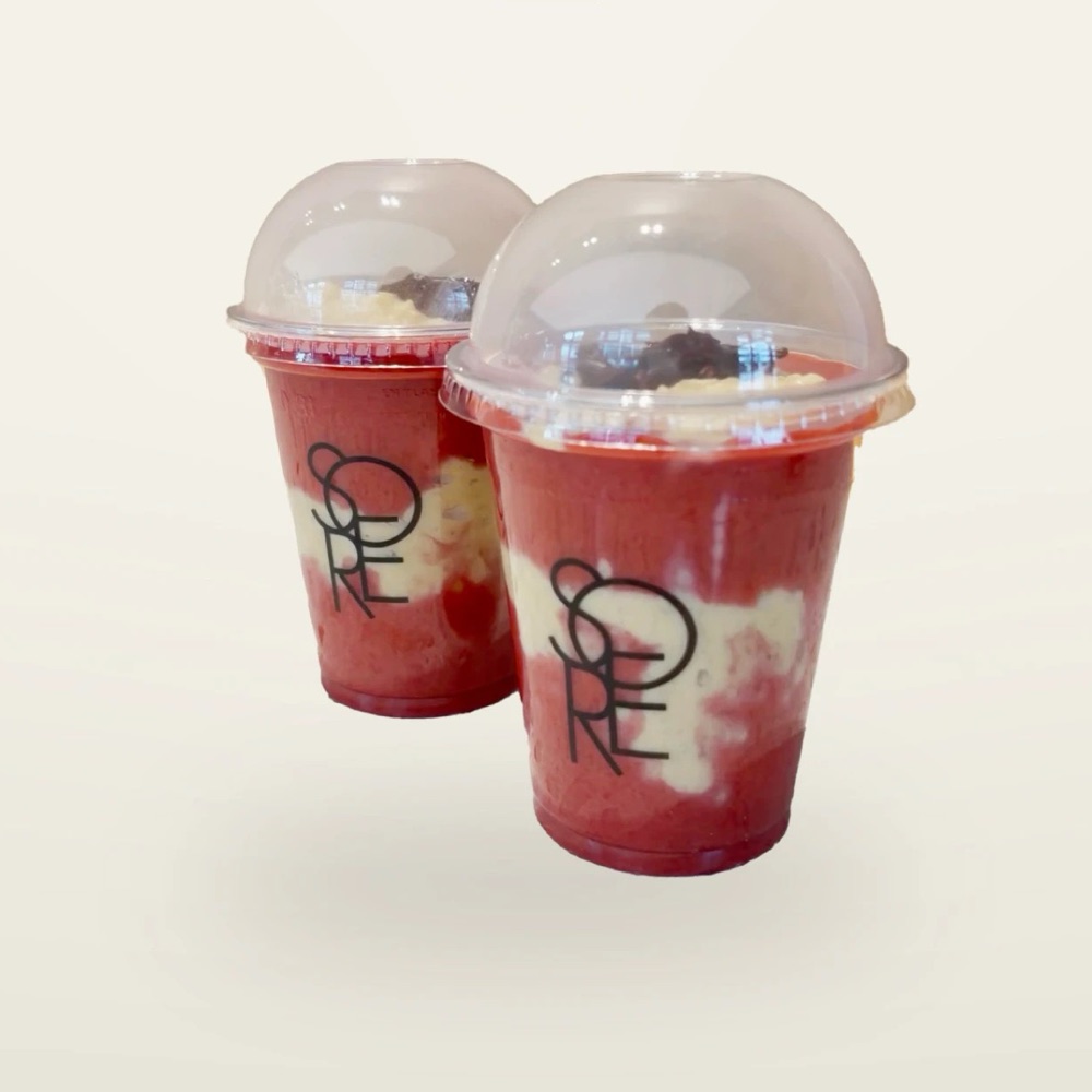 Zwei Becher mit Fruchtschicht, Creme und Topping