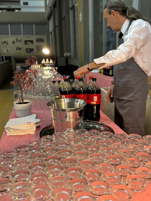 Σερβιτόρος τοποθετεί αναψυκτικά σε πάγκο εκδήλωσης