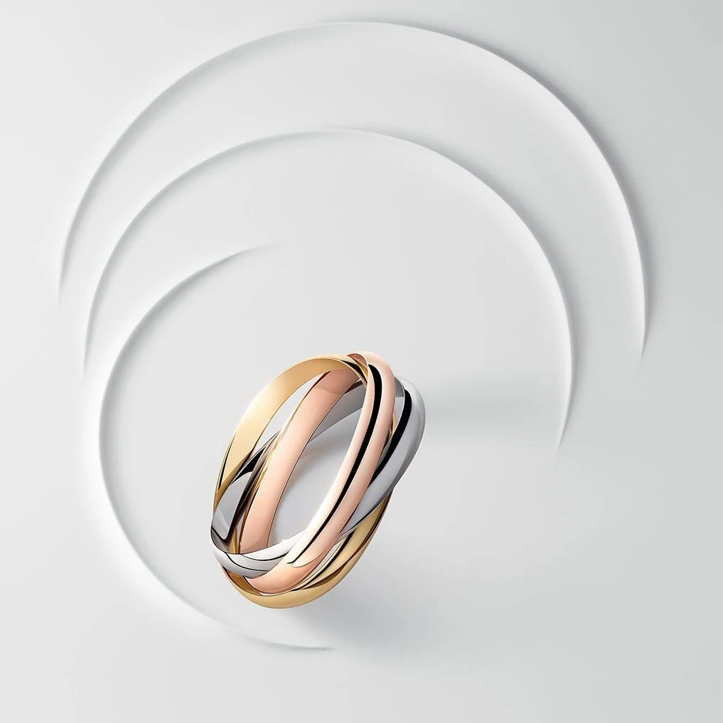 La légendaire bague Trinity de Cartier sur fond blanc.