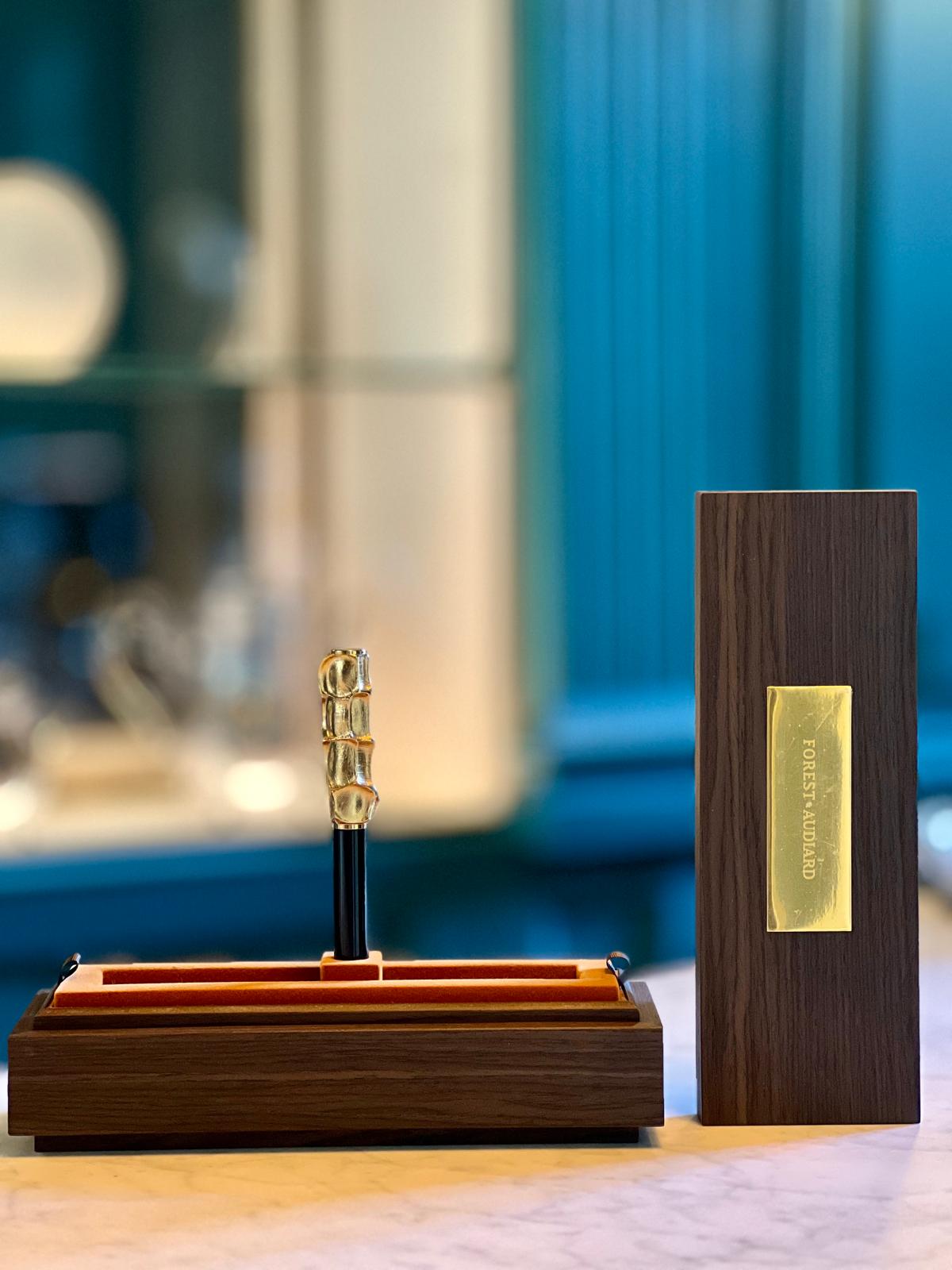 Stylo-Sculpture Forest Audiard en bronze doré, posé dans son écrin en bois, symbole d’élégance, de geste et de transmission.