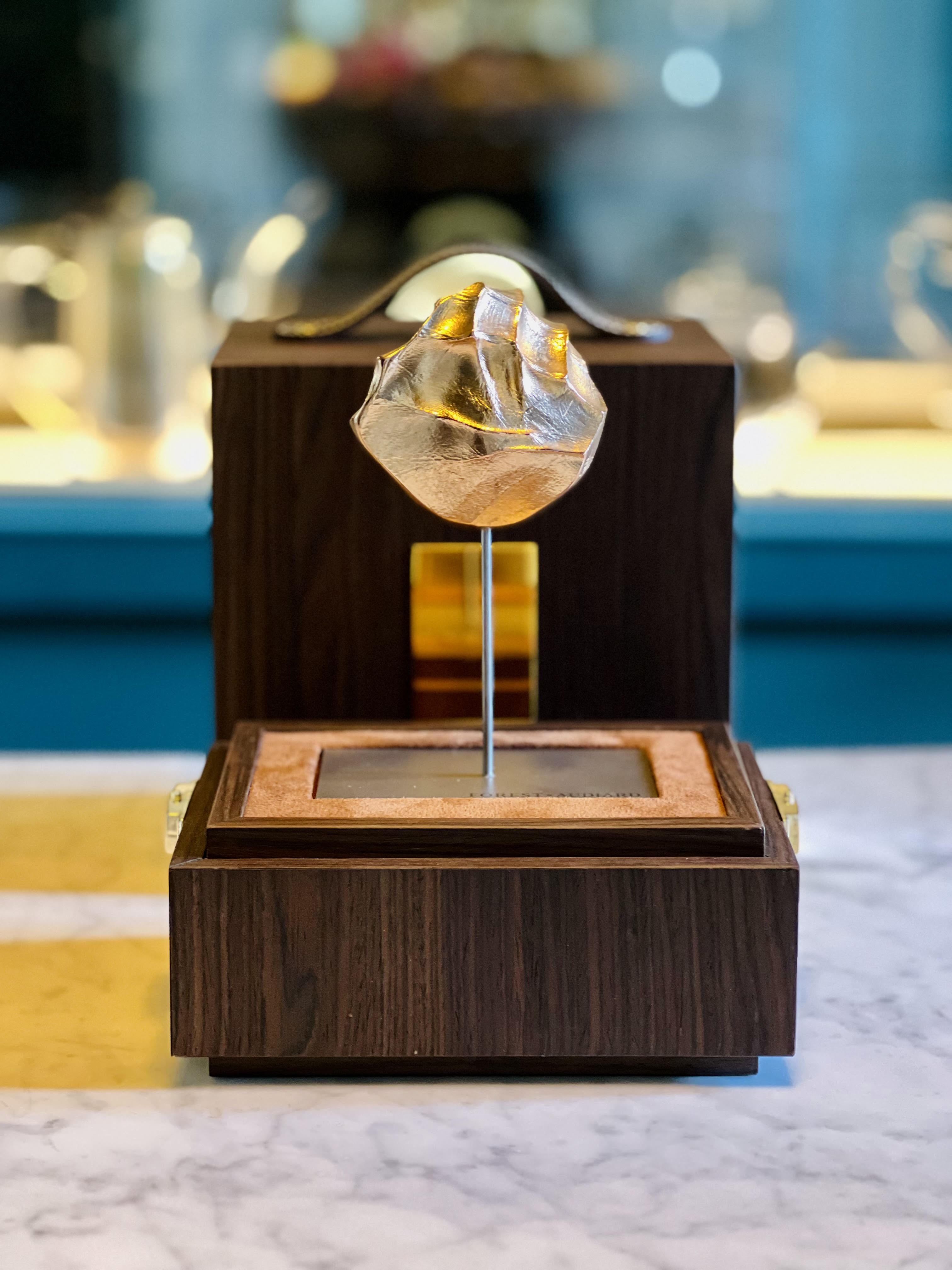 The Étreinte by Forest Audiard in its smoked oak case, a living artwork embodying love and beauty, offered at Christmas.