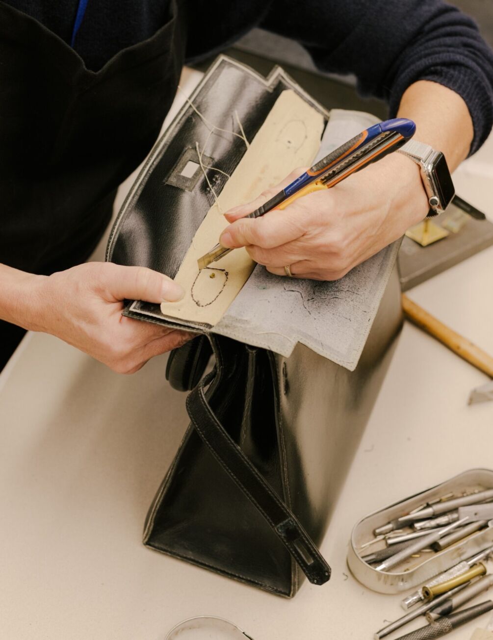 Geste de précision dans le travail du cuir chez Hermès, symbole du lien entre la matière, la main et la création d’exception à la française.