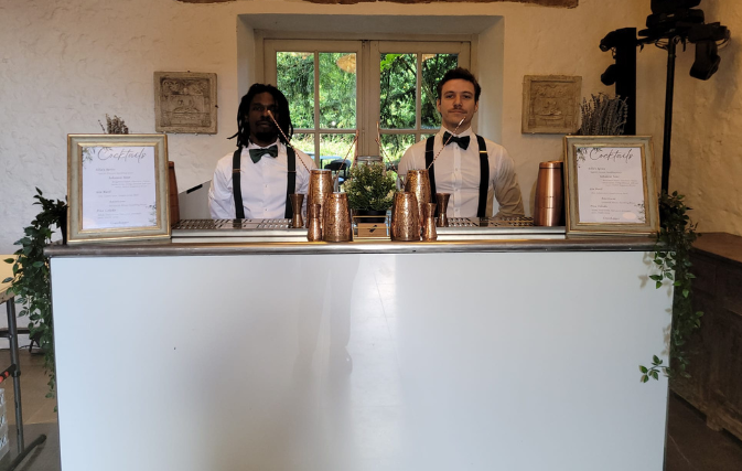 Un groupe souriant assis au bar avec des cocktails.