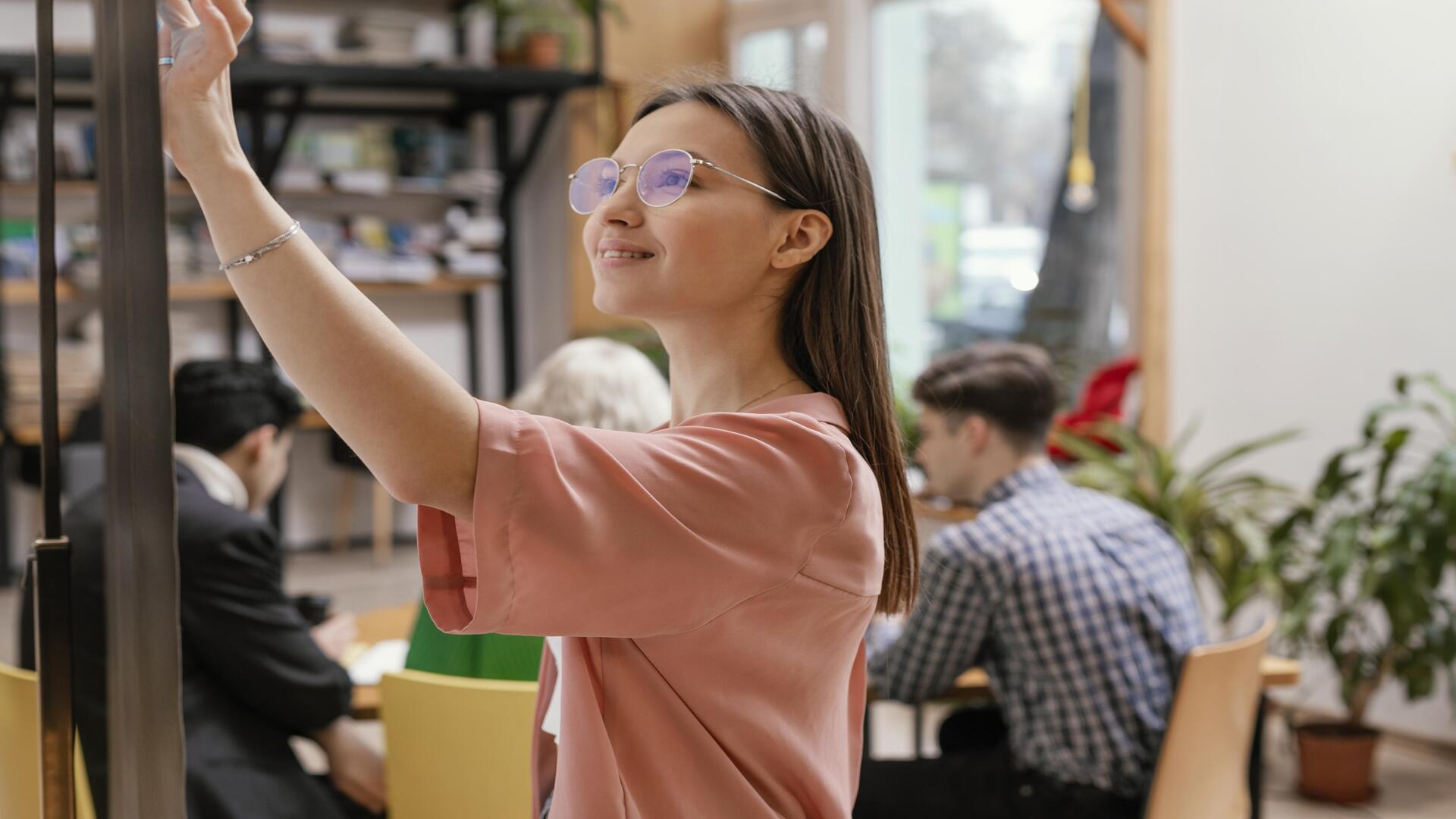 femme écrivant sur un tableau en entreprise
