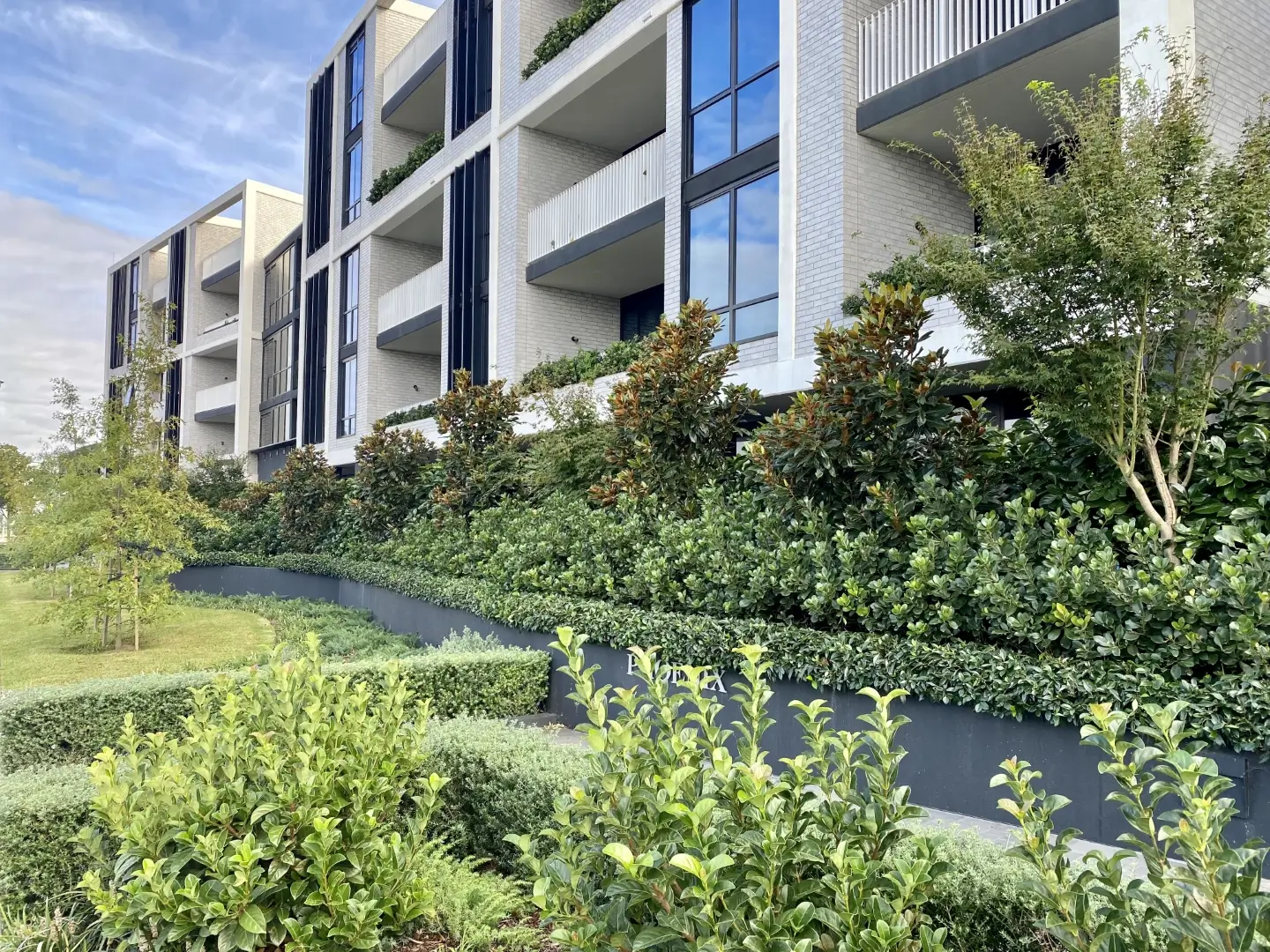 Curve-shaped feature garden in front of apartment block