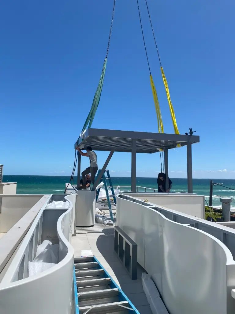 Rooftop balcony shade being assembled by several workers