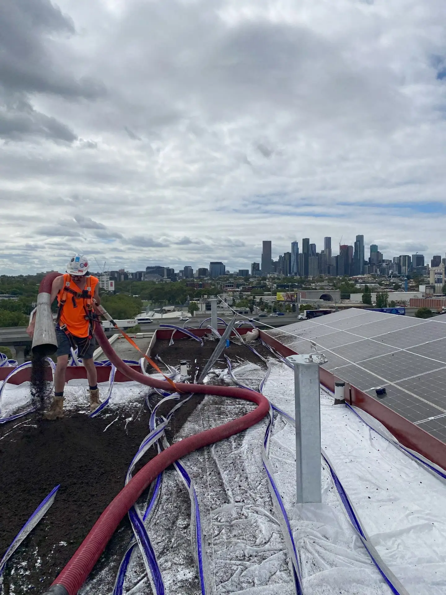A worker pumping soil up onto the roof garden