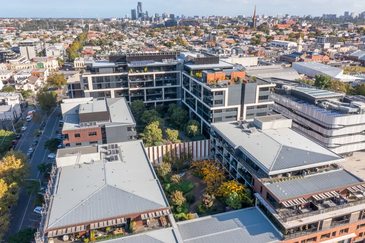 Aerial view of modern urban development with green spaces and city skyline