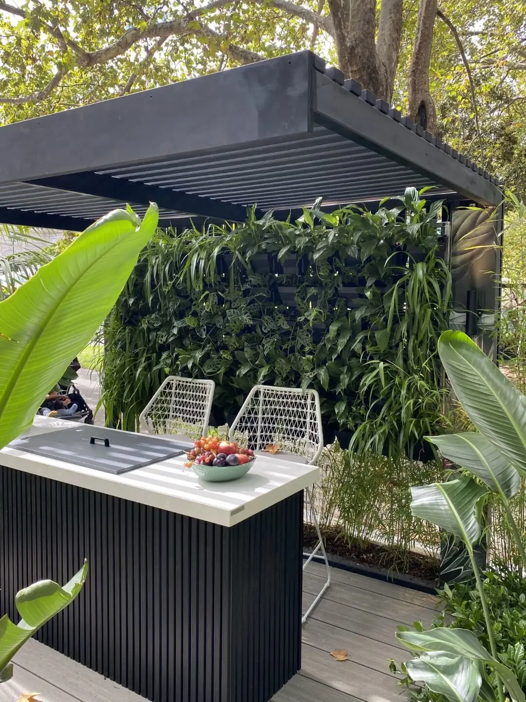 Modern outdoor kitchen with vertical garden and tropical plants