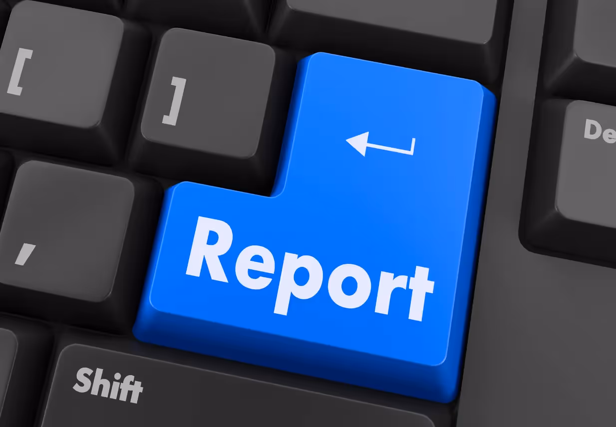 A blue "report" button prominently displayed on a computer keyboard key, surrounded by other standard black keys.