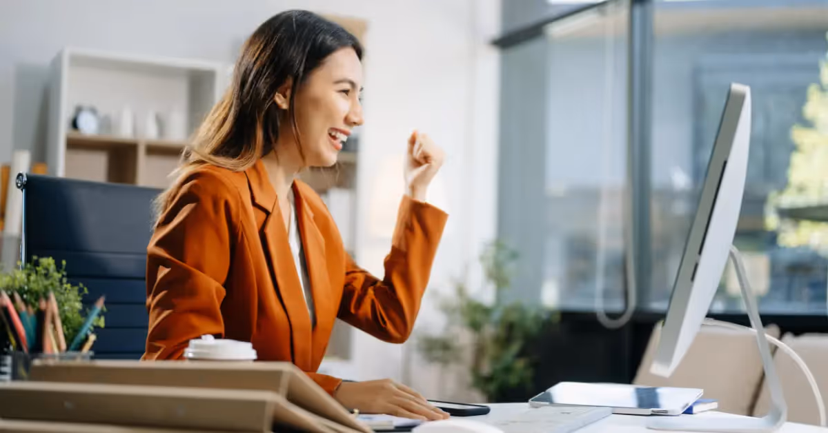 a happy accountant celebrating a job well done while working on her computer