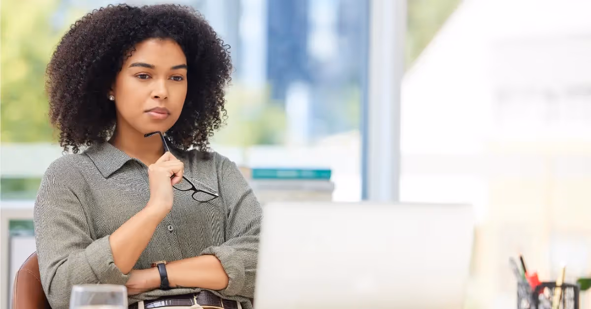 Accountant looking at her laptop thinking 