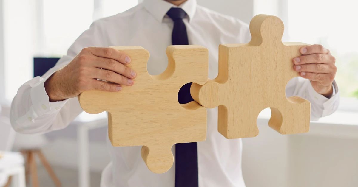 man connecting puzzle pieces like integrators and integrations in a ERP