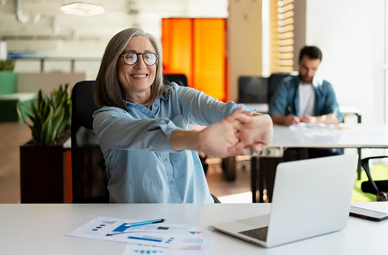 accountant stretching arms at desk looking happy