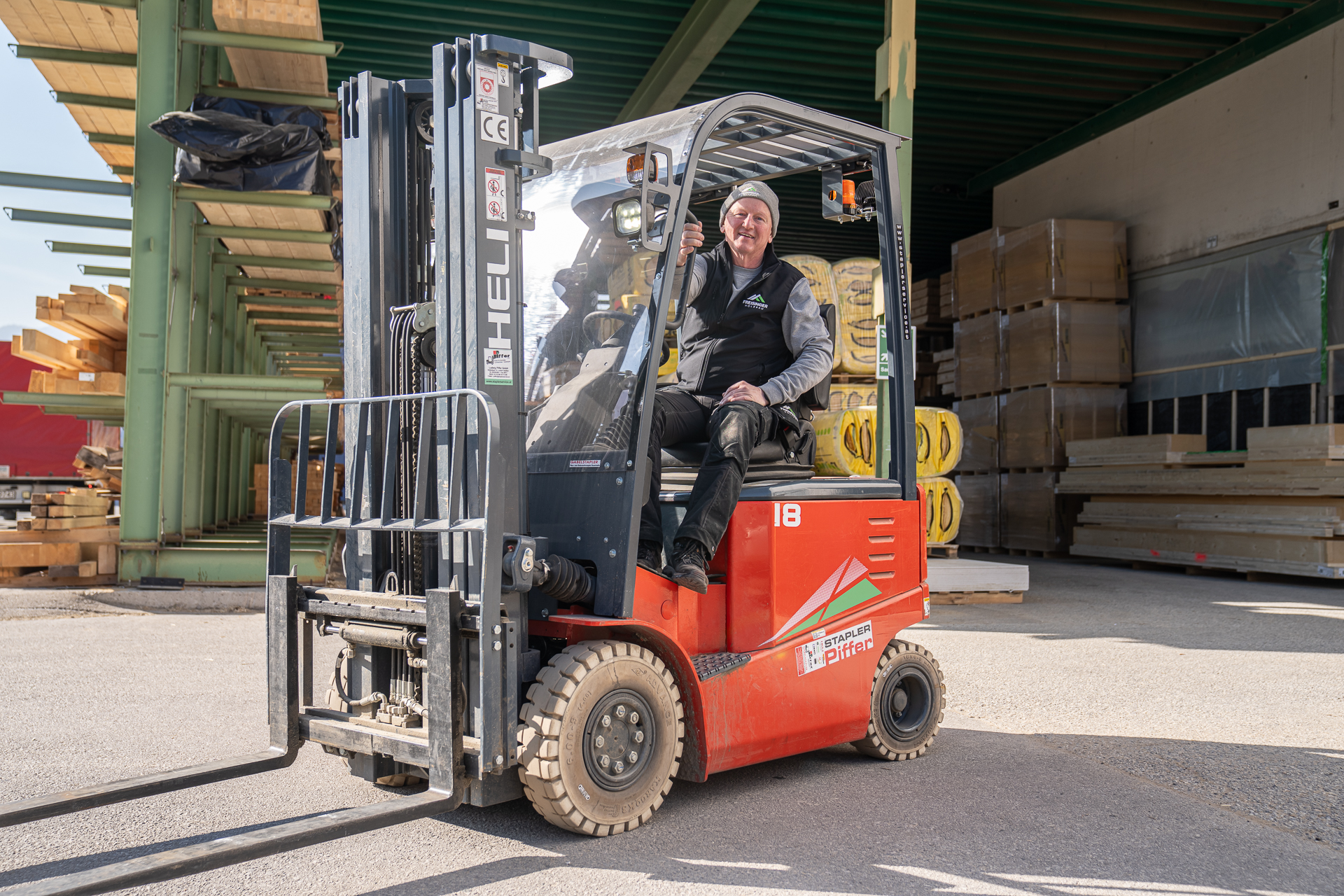 Mitarbeiter der Zimmerei beim Holzlager mit Gabelstapler – effiziente Materiallogistik und professioneller Holzbau im Betriebsalltag.