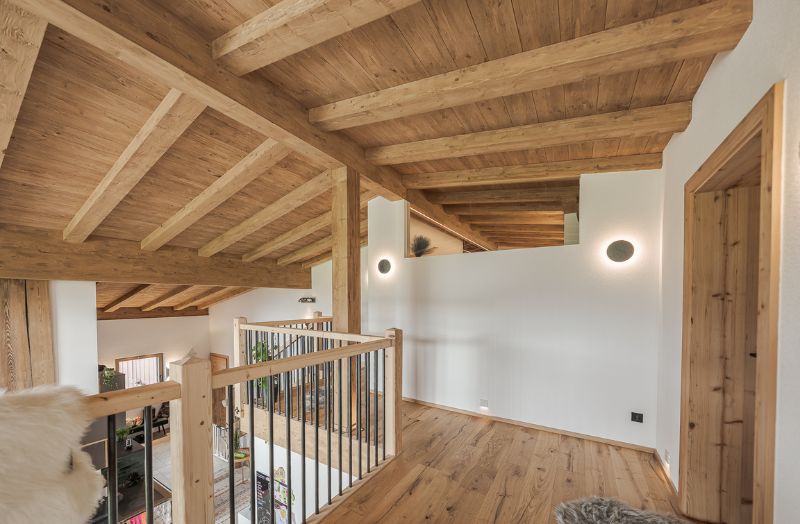 Moderner Innenraum in Holzbauweise mit sichtbarer Massivholzdecke, Galerie und Holzboden – hochwertiger Innenausbau mit natürlichem Wohnambiente.