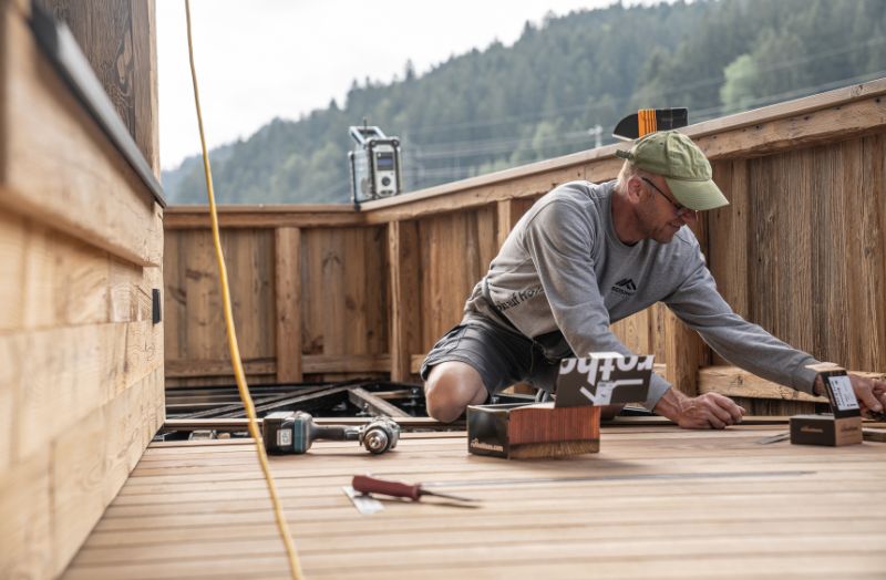 Zimmerer bei der Montage einer Holzterrasse – präziser Holzbau im Außenbereich mit hochwertiger Verarbeitung und handwerklichem Know-how.