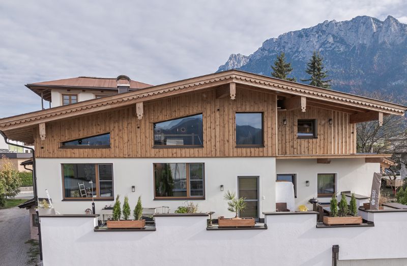 Einfamilienhaus in traditioneller Holzbauweise mit Naturholzfassade, Satteldach und Bergpanorama – hochwertiger Holzbau mit alpinem Charakter.