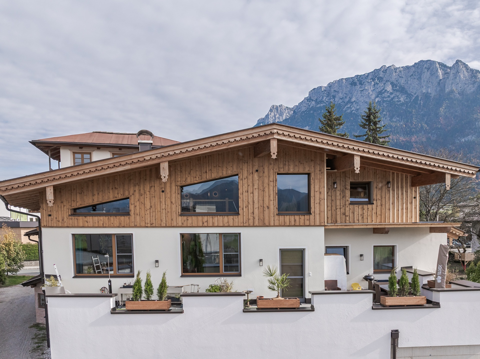 Einfamilienhaus in traditioneller Holzbauweise mit Naturholzfassade, Satteldach und Bergpanorama – hochwertiger Holzbau mit alpinem Charakter.