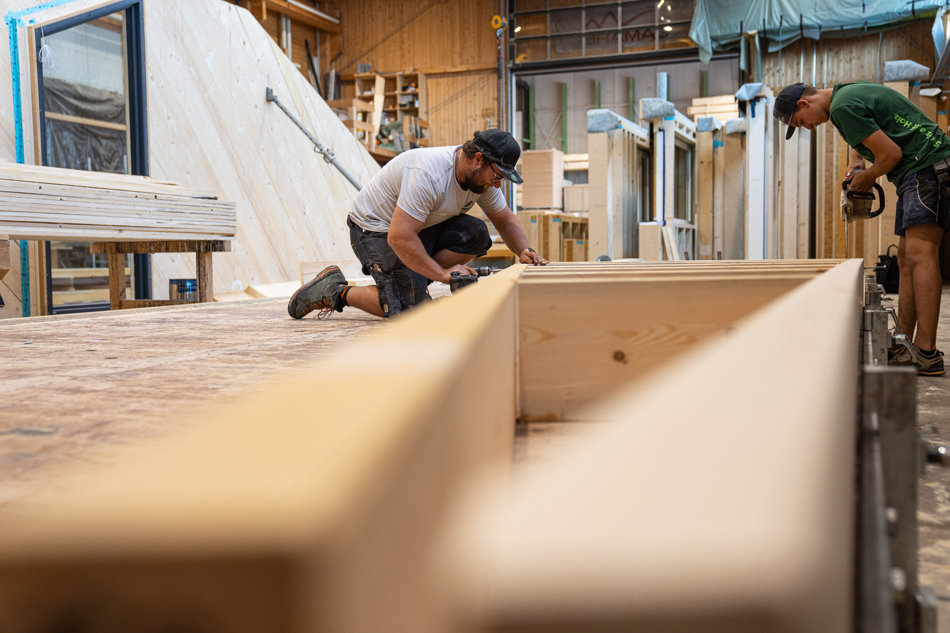 Zimmerer von Freisinger Holzbau bei der Fertigung von Holzelementen in der Zimmerei in Ebbs – Einblick in den Arbeitsalltag und Karriere im Holzbau.