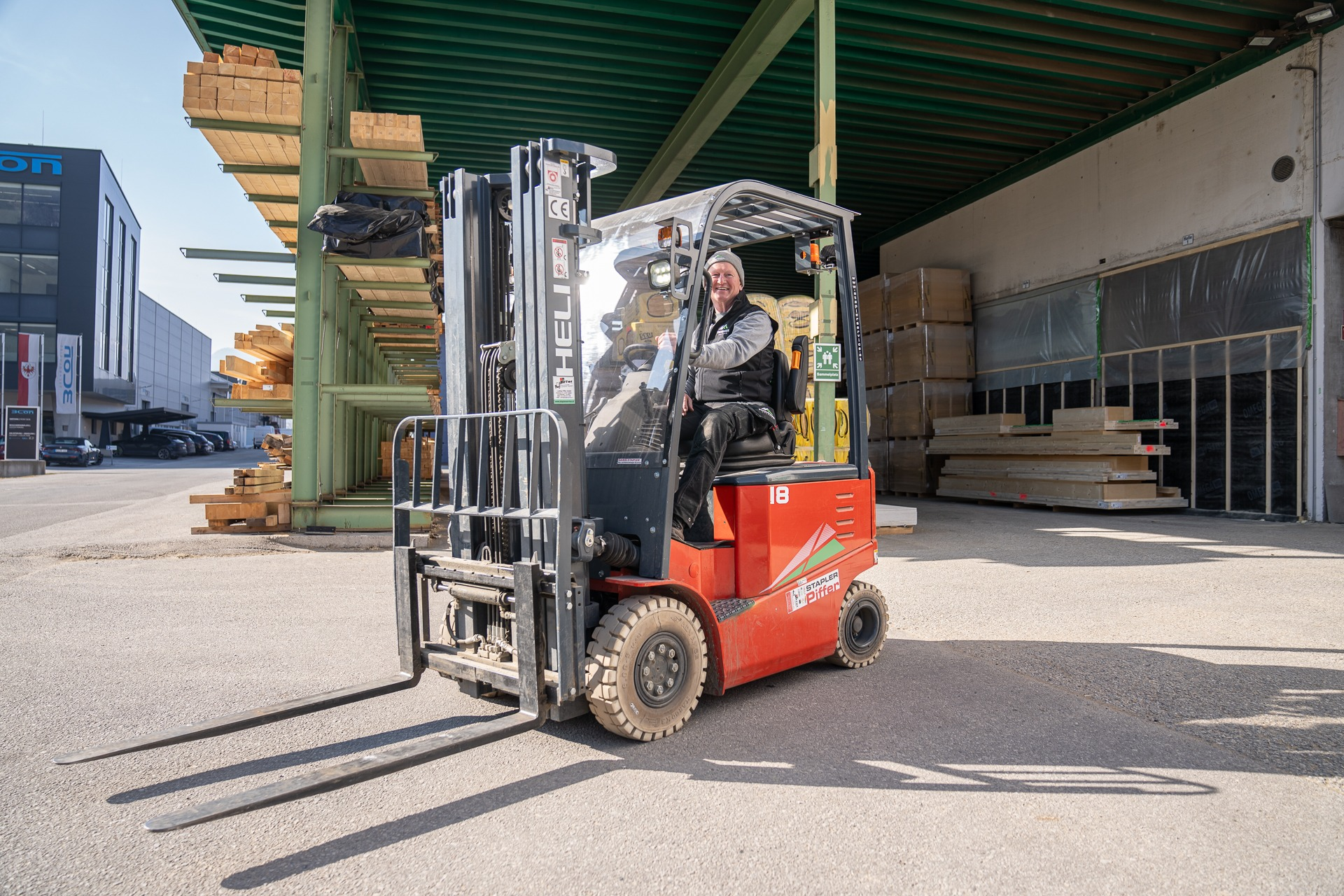 Mitarbeiter der Zimmerei beim Holzlager mit Gabelstapler – effiziente Materiallogistik und professioneller Holzbau im Betriebsalltag.