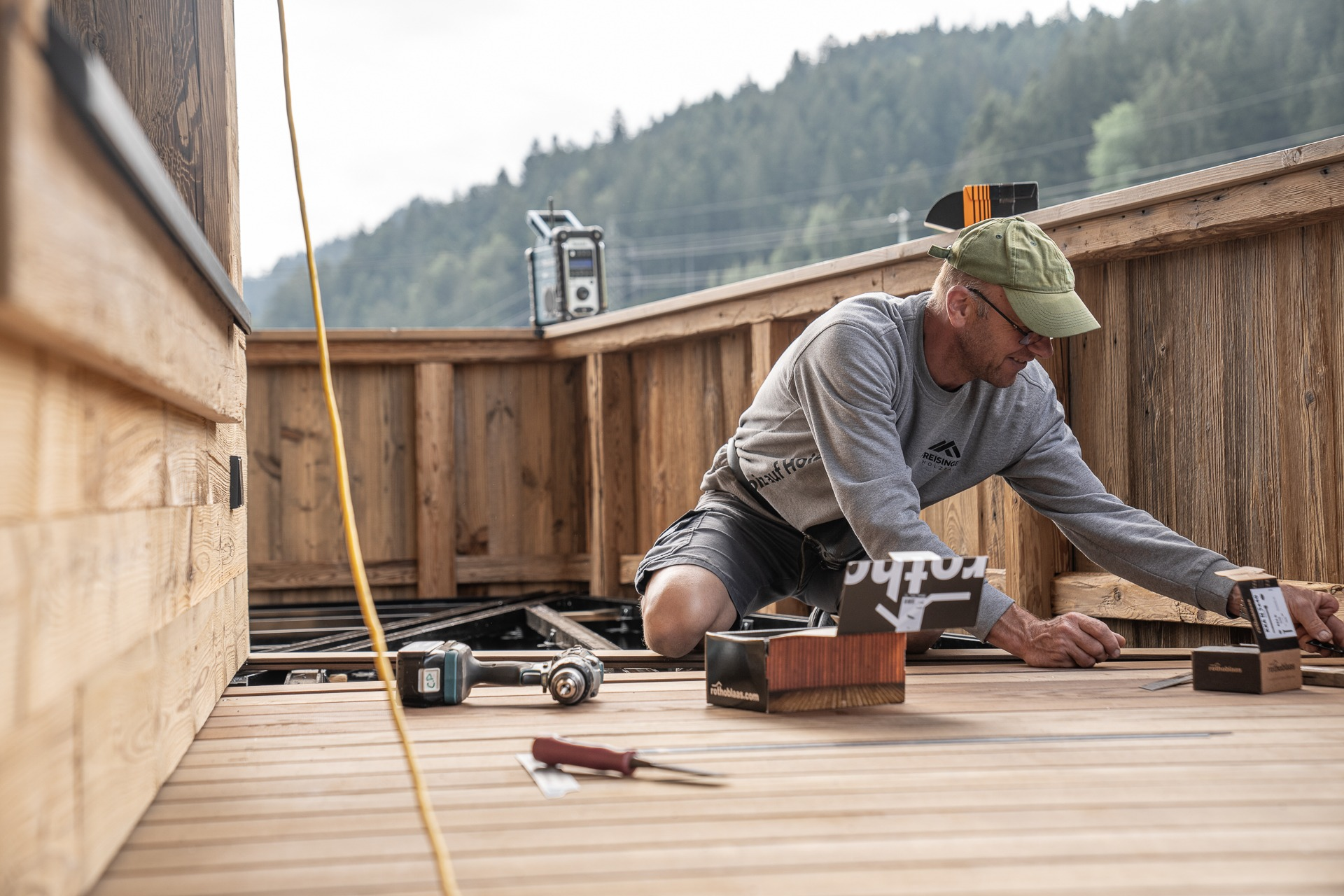 Zimmerer-Vorarbeiter von Freisinger Holzbau beim fachgerechten Verlegen eines Terrassenbodens aus Holz auf einer Baustelle in Tirol.