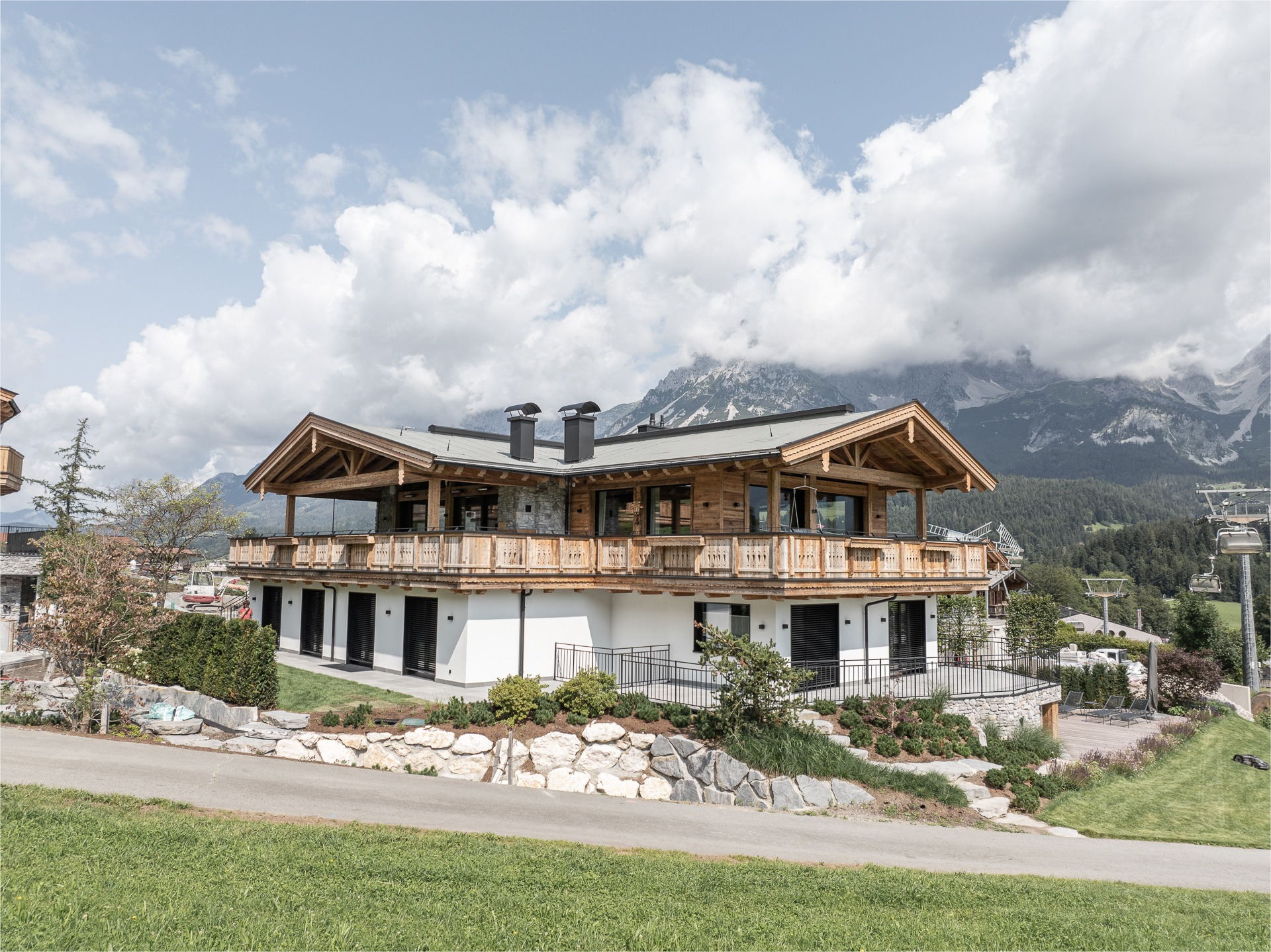 Modernes Wohnhaus im alpinen Holzbaustil mit Holzfassade, Sichtdachstuhl und Holzbalkon vor dem Kaisergebirge in Tirol