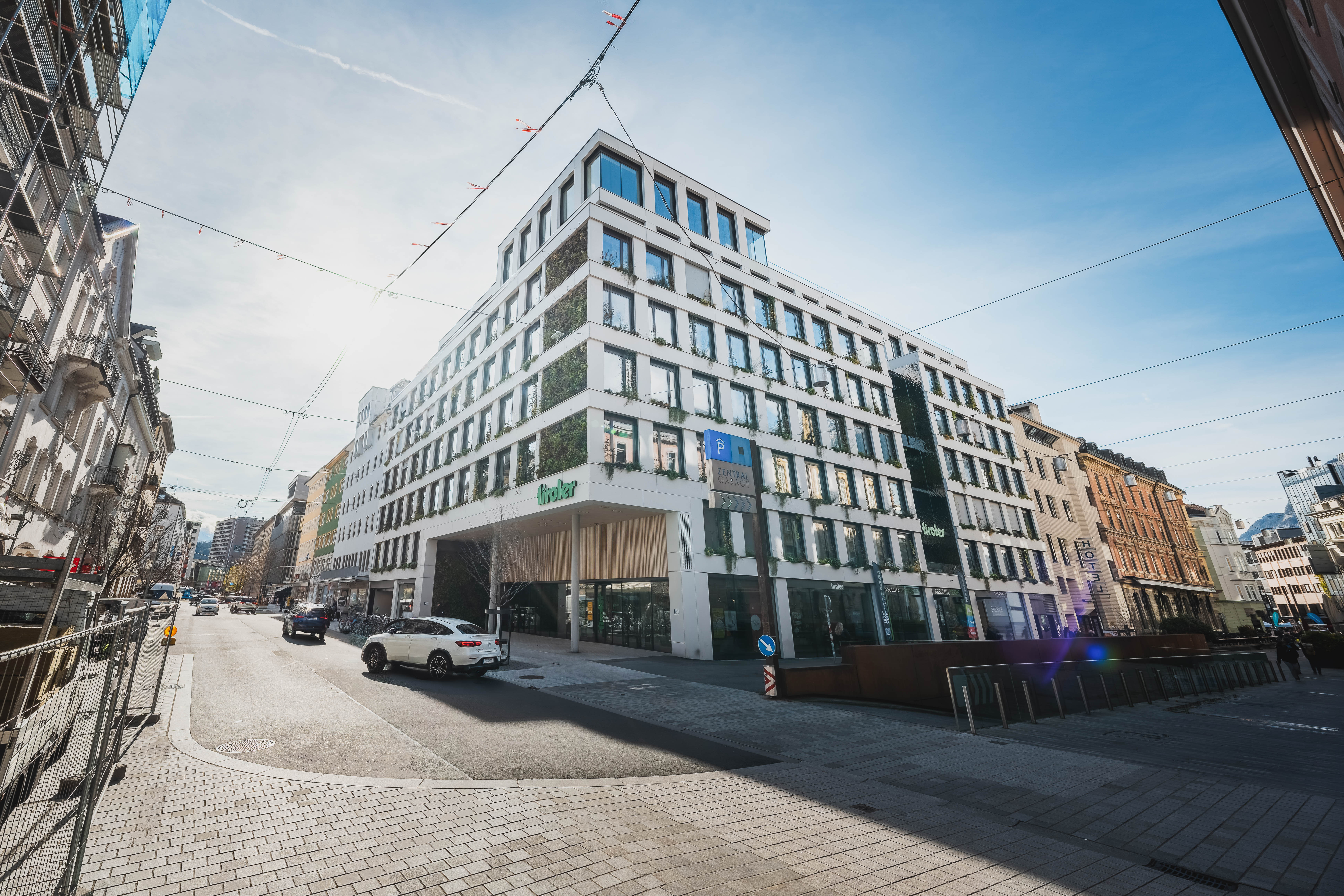Modernes Büro- und Geschäftsgebäude im urbanen Umfeld mit großflächigen Fenstern, begrünter Fassade und zeitgemäßer Architektur im Stadtzentrum.