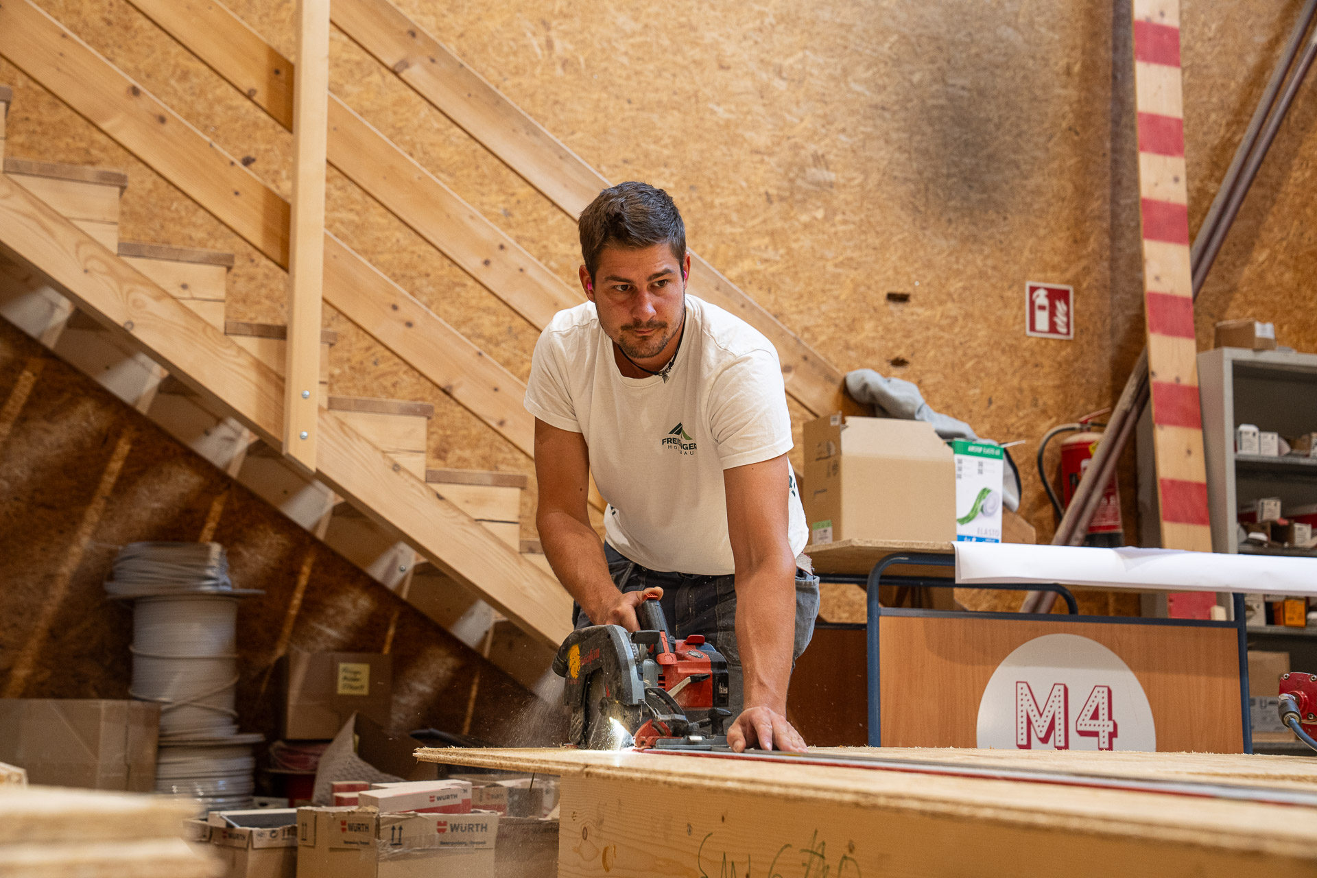 Zimmerer von Freisinger Holzbau bei der Holzbearbeitung in der Werkstatt – Karriere und Arbeiten im Holzbau in Tirol.