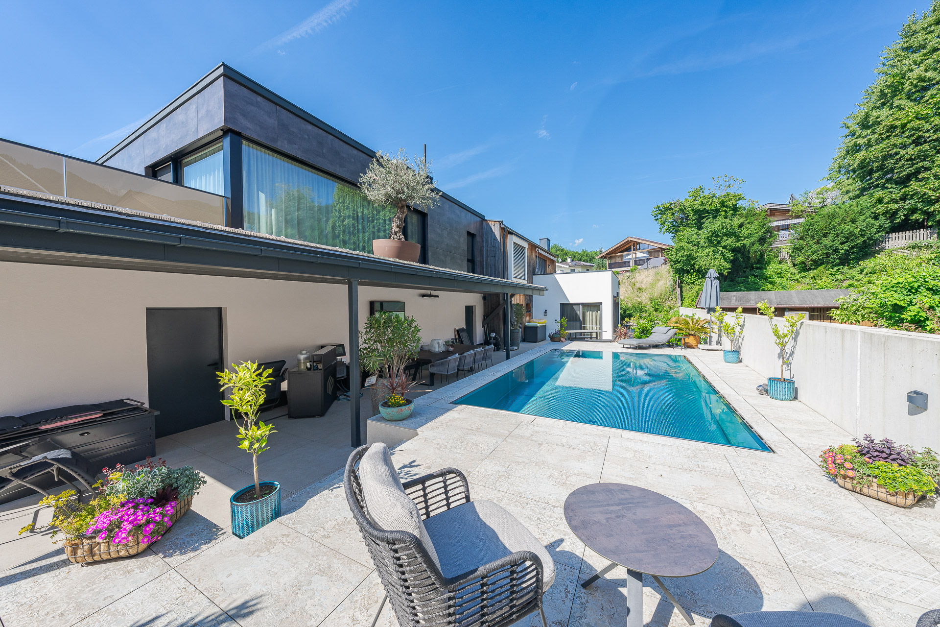 Modernes Wohnhaus mit Holzelementen, großzügiger Terrasse und Pool als Inspiration für zeitgemäßen Holzbau von Freisinger Holzbau