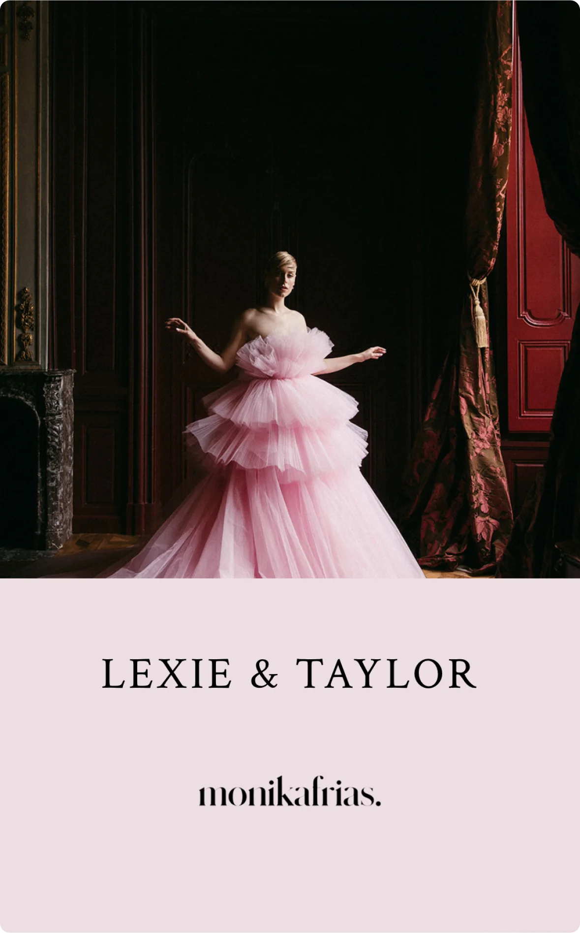 Dramatic bridal portrait of a woman in a voluminous pink gown, striking a pose in front of heavy velvet drapes in a grand room. Photo by Monika Frias.