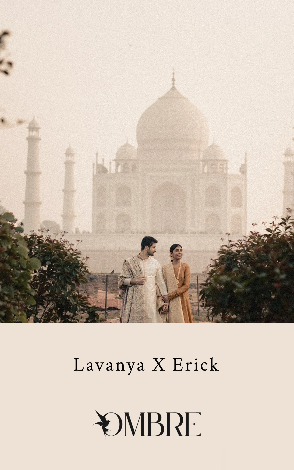 Romantic portrait of a couple in traditional Indian attire standing hand-in-hand in front of the Taj Mahal, surrounded by mist and foliage.