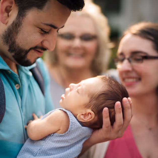 A man holding a baby in front of a group of people