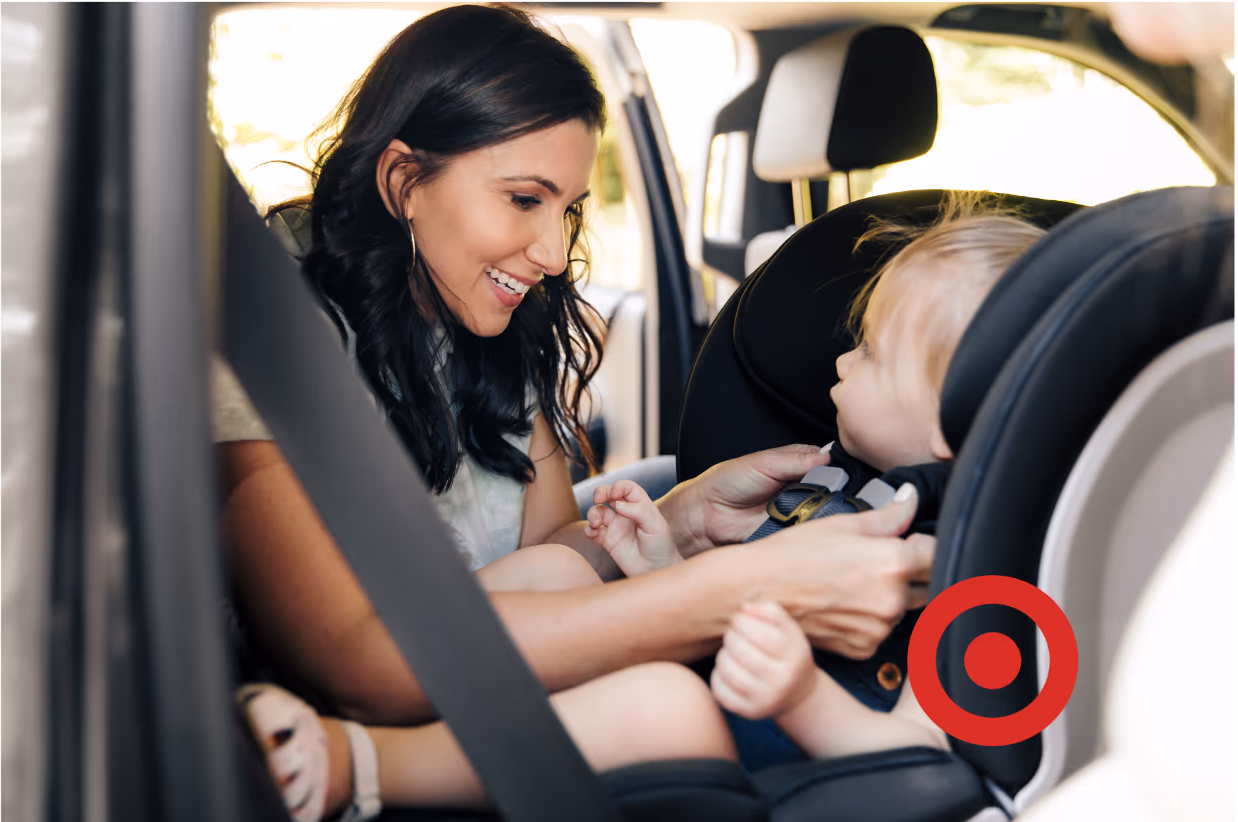 A woman tucking a child into a car seat