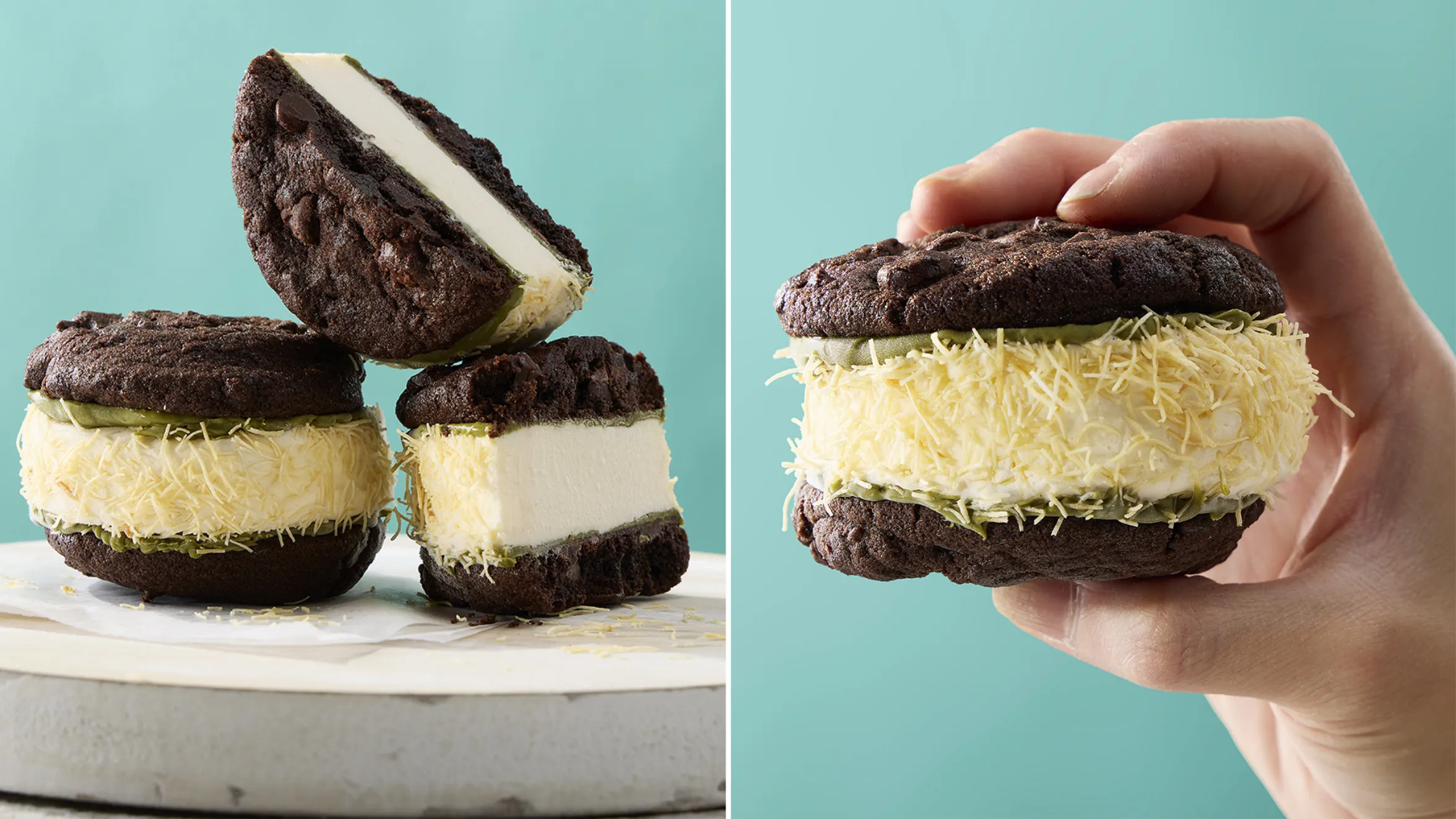 Chocolate cookie ice cream sandwiches filled with vanilla ice cream and a layer of shredded pistachio and cream topping; one is shown being held in a hand against a turquoise background.