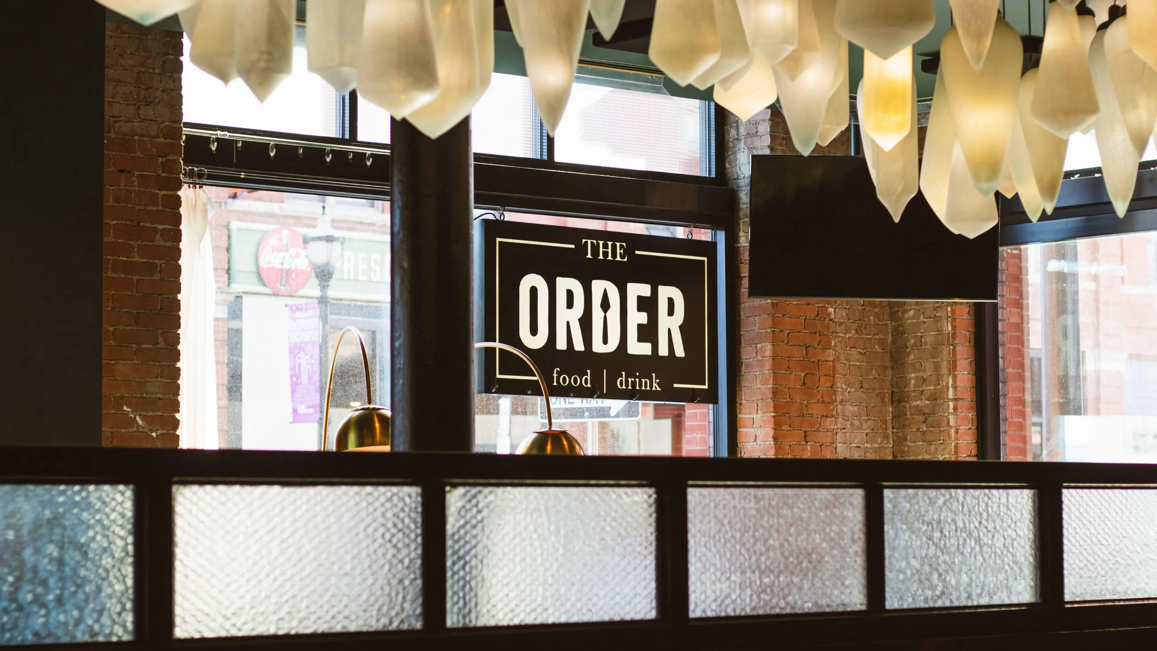 Logo for The Order food and drink, featuring the word ORDER with a utensil shape integrated into the letter D, enclosed in a white rectangular frame.