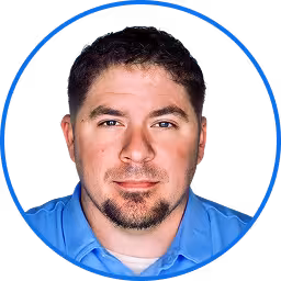 Professional headshot of a man in a blue shirt.