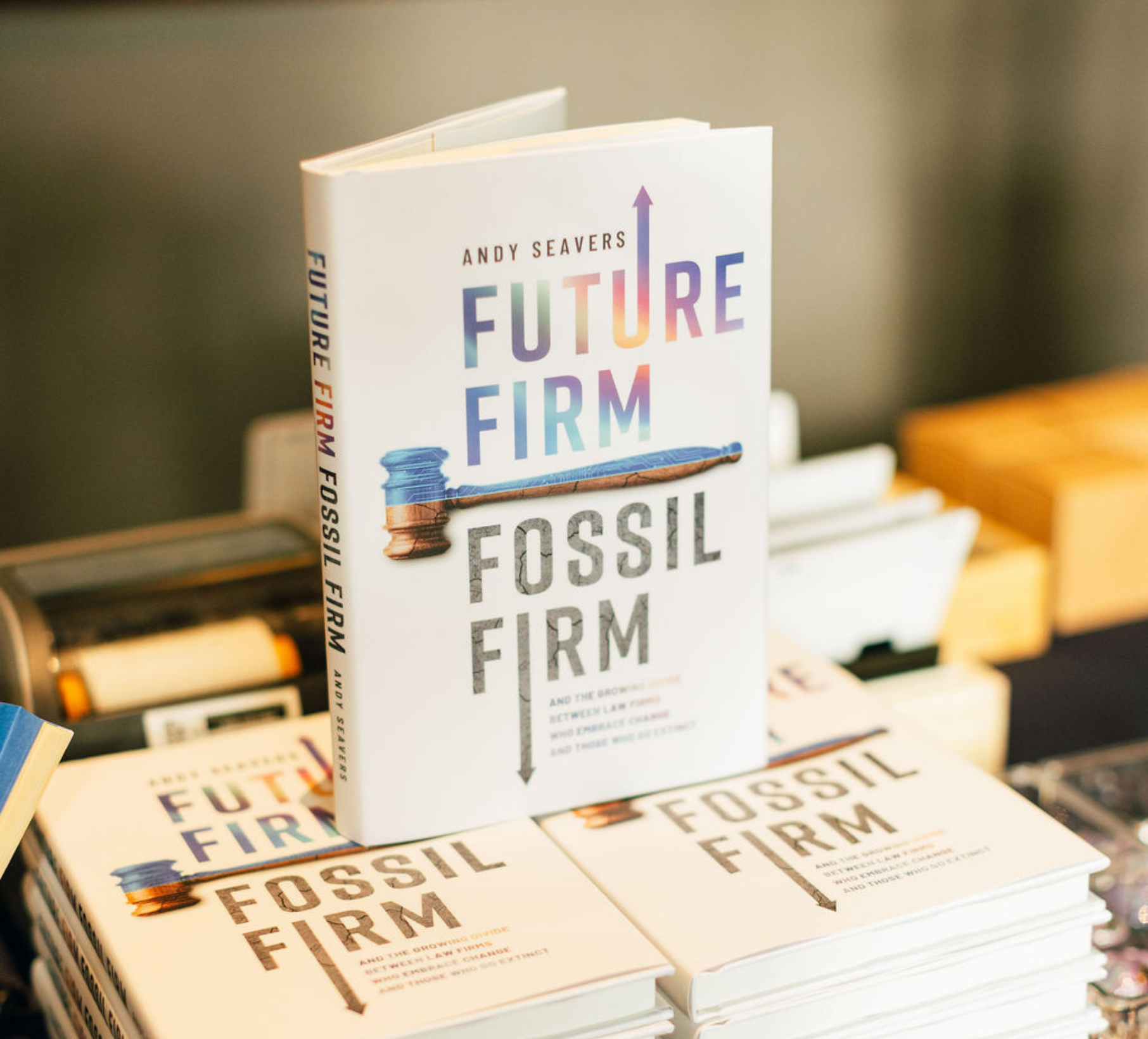 Stack of books titled 'Future Firm Fossil Firm' by Andy Seavers, with a gavel illustration on the cover.