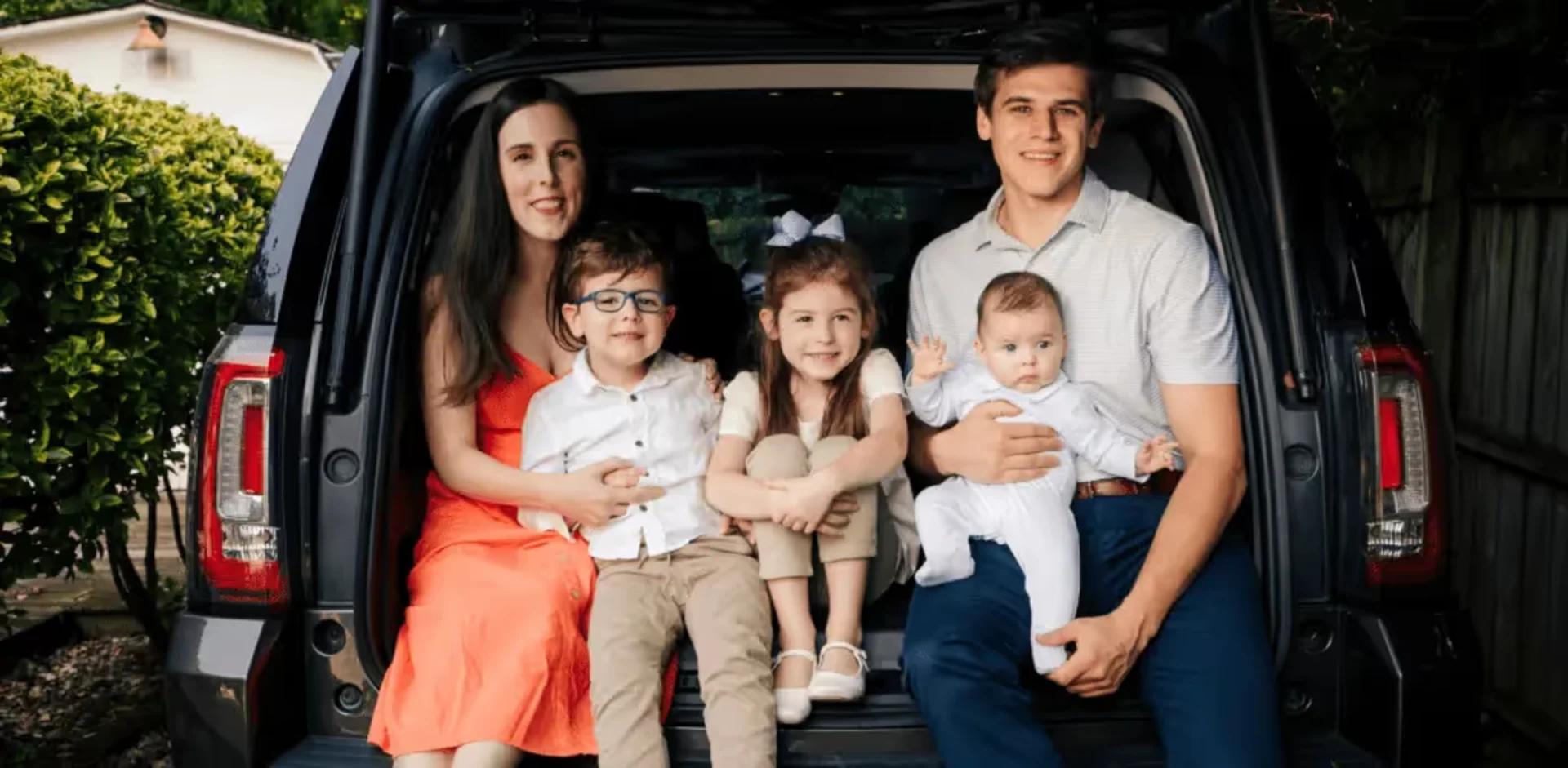 A family sitting in the back of a van