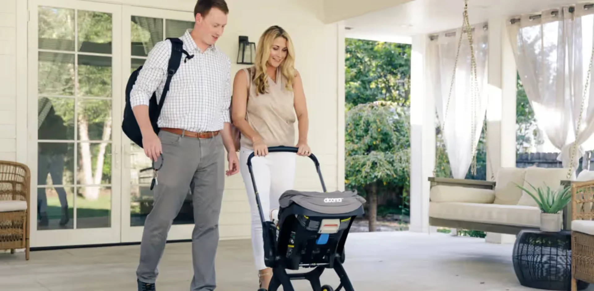 A woman pushing a stroller with a man standing next to it