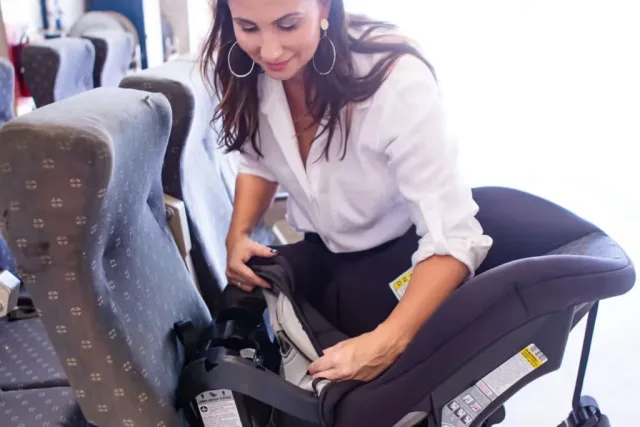 A woman sitting in a baby car seat