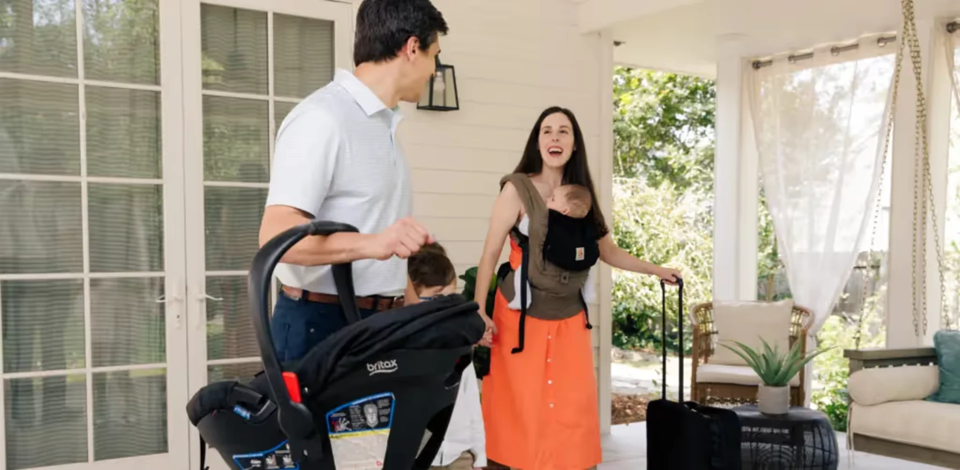 A man standing next to a woman holding a baby in a stroller