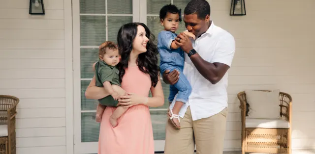 A man is holding a baby and a woman is holding a toddler