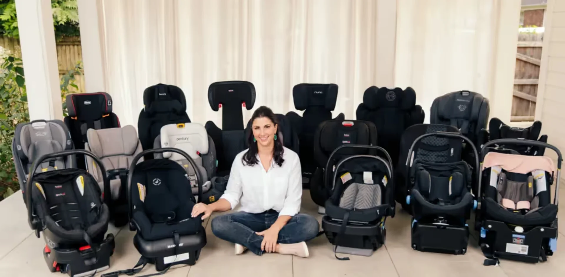 A woman sitting in front of a bunch of baby seats