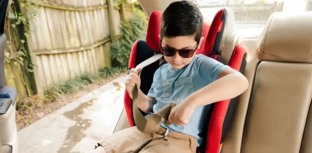 A young boy sitting in the back seat of a car