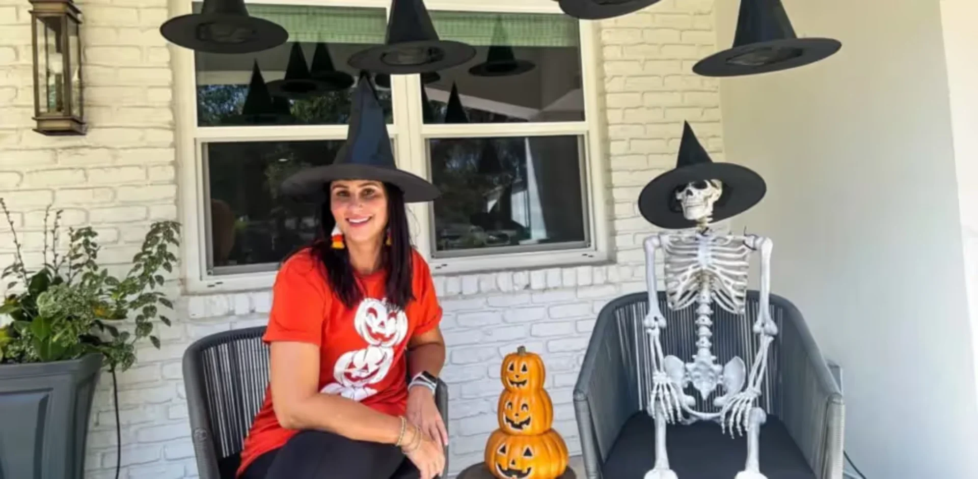 A woman sitting on a chair in front of a house