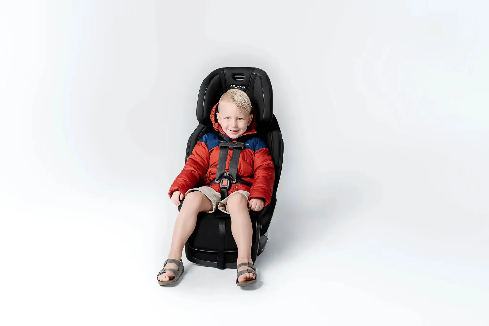 A little boy sitting in a car seat